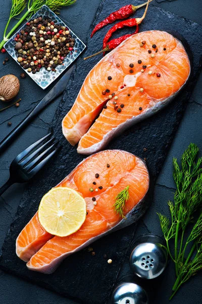 Salmon steaks with lemon on stone desk — Stock Photo, Image