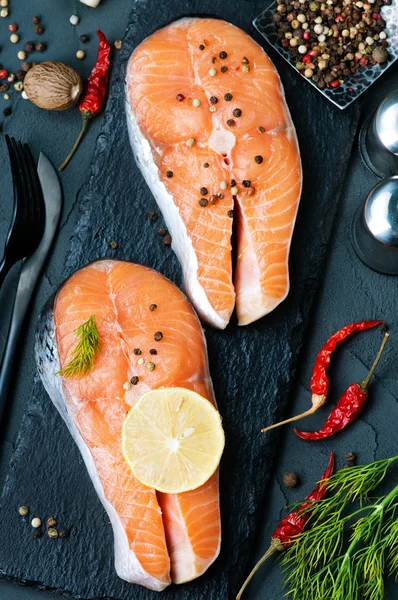 Salmon steaks with lemon on stone desk — Stock Photo, Image