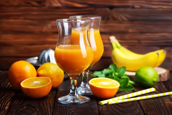 Стаканы апельсинового сока и фруктового стола — стоковое фото
