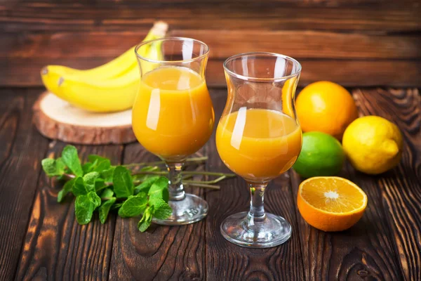 Glazen oranje sap en fruit tabel — Stockfoto