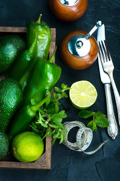 Avocado with lime and green pepper in wooden box — Stock Photo, Image