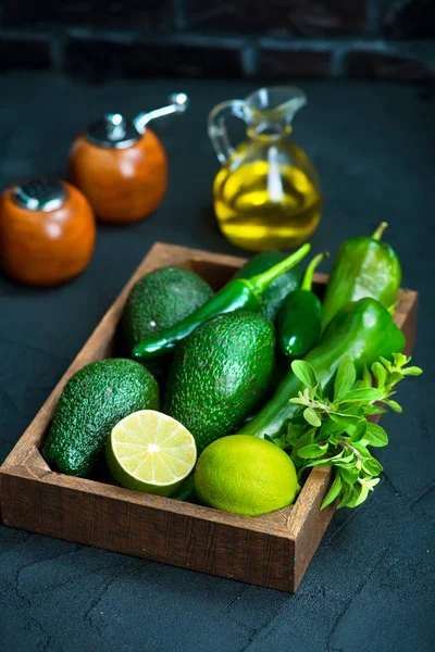 Avocado mit Limette und grünem Pfeffer in Holzkiste — Stockfoto
