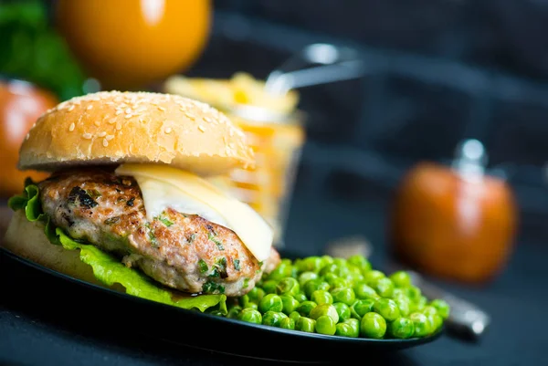 Hamburger et légume sur plaque noire — Photo