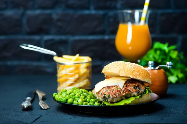 Hamburguesa y legumbre en plato negro — Foto de Stock