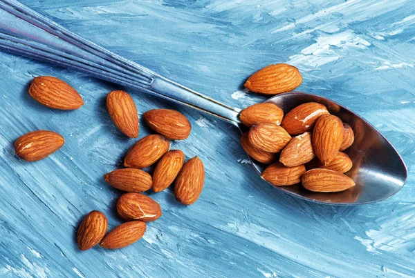 Almonds with iron spoon — Stock Photo, Image