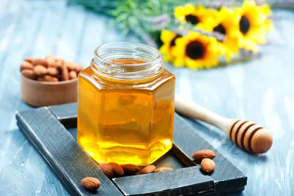 Honey and almonds on table — Stock Photo, Image