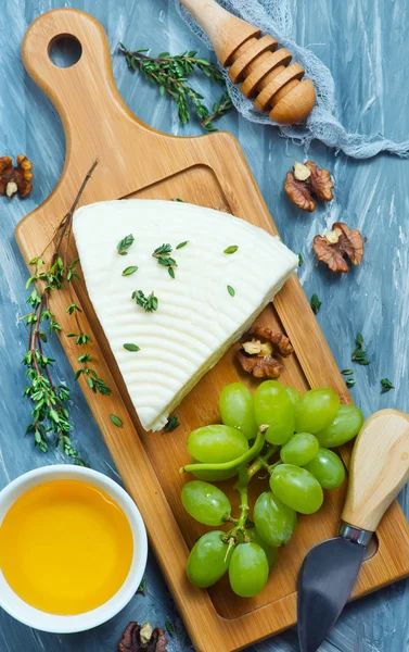 Cheese with grapes and walnuts — Stock Photo, Image
