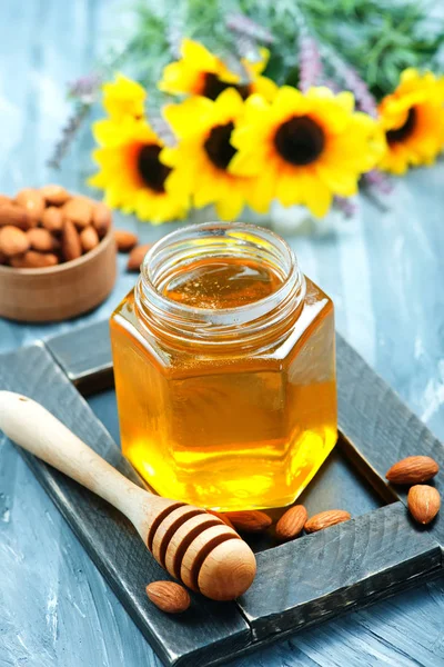 Honey and almonds on table — Stock Photo, Image