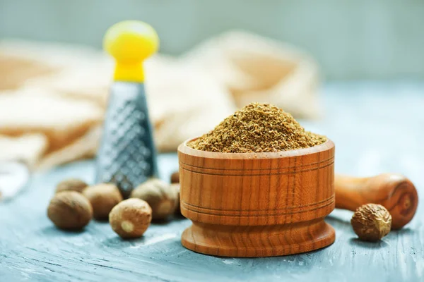Nutmegs and powder in bowl — Stock Photo, Image