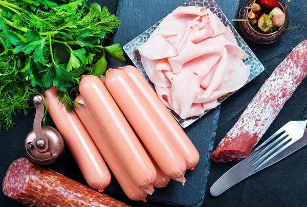 Salsicce e prosciutto sul tavolo da pranzo — Foto Stock