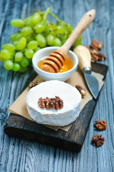 Camembert mit Honig an Bord — Stockfoto