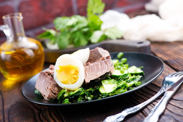 Salad with eggs on black plate — Stock Photo, Image