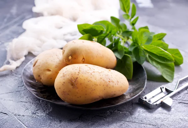 Raw potatoes on table — Stock Photo, Image