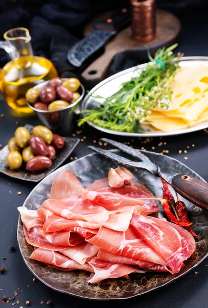 Prosciutto su piatto con erbe aromatiche — Foto Stock