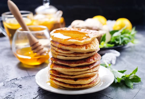 Pannkakor med honung på tallriken — Stockfoto