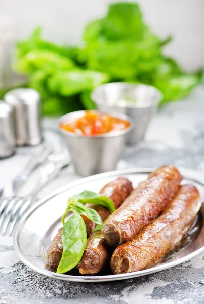 Sausages on metal plate — Stock Photo, Image