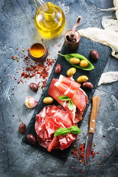 Prosciutto with olives and spice — Stock Photo, Image