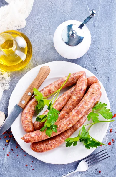 Sausages with spice and utensils — Stock Photo, Image