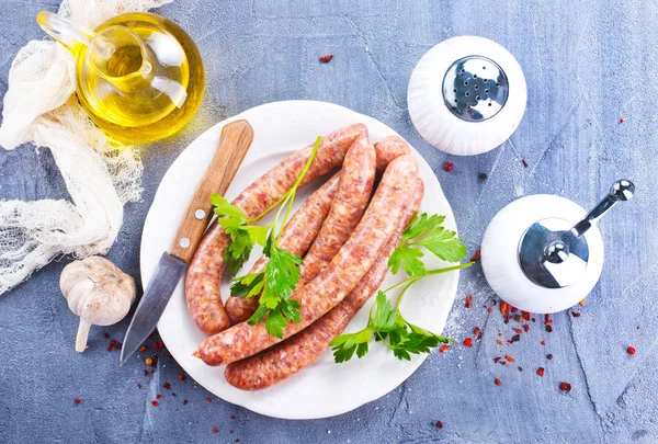 Sausages with spice and utensils — Stock Photo, Image