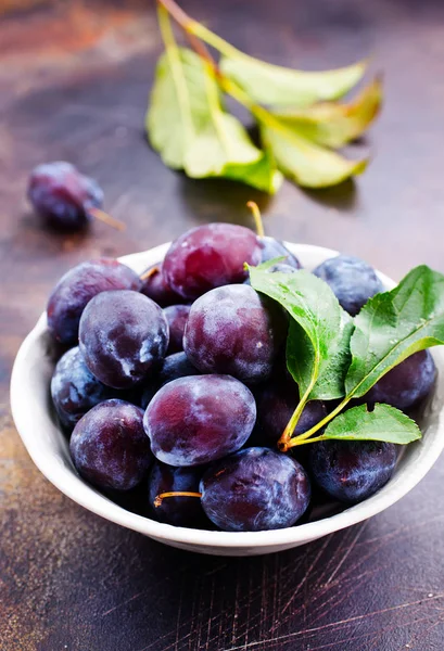 Plums in plate on table — Stock Photo, Image