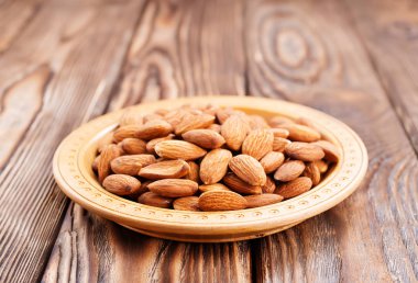 ahşap masa üzerinde kızarmış badem