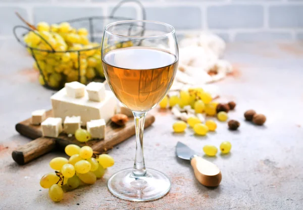 Vinho branco com queijo e uvas — Fotografia de Stock