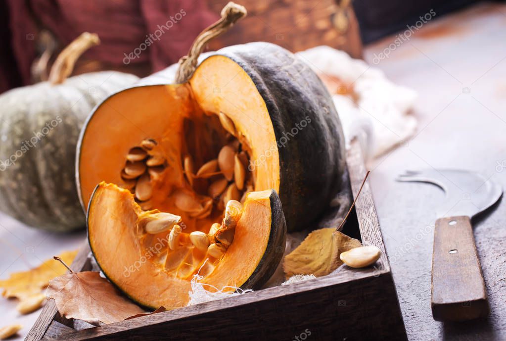 raw pumpkin on a table on wooden board 