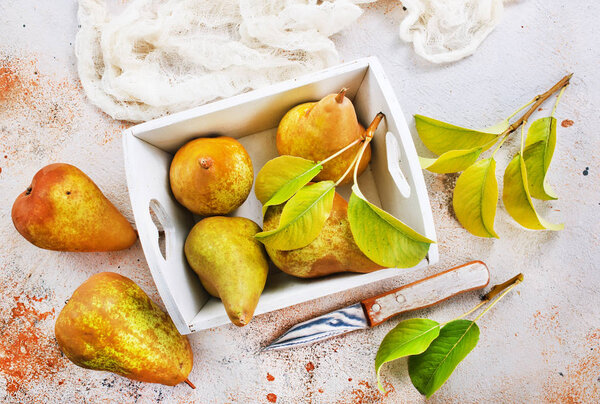 Fresh pears in wooden basket on a table