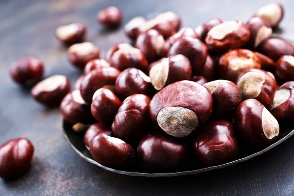 Raw chestnuts in plate — Stock Photo, Image