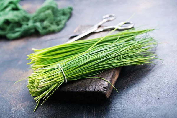 Зеленый лук на деревянной доске — стоковое фото