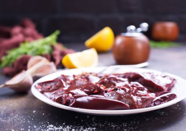 pişmemiş karaciğer koyu arka plan üzerinde tabakta görmek 