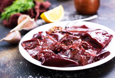 pişmemiş karaciğer koyu arka plan üzerinde tabakta görmek 