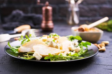 Tatlım, fındık ve siyah plaka üzerinde peynir ile armut 