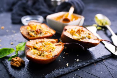 Tatlım, fındık ve siyah taş levha üzerine peynir pişmiş armut