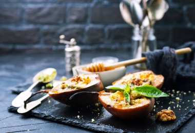 Tatlım, fındık ve siyah taş levha üzerine peynir pişmiş armut