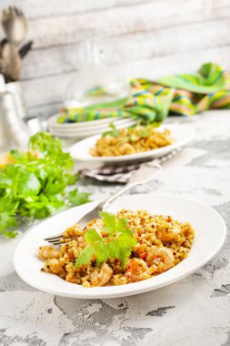 Kızarmış bulgur ve beyaz tabakta karides.