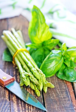 ahşap masa, yeşil kuşkonmaz üzerinde ham kuşkonmaz