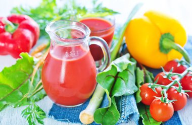 Bardakta ve masada taze sebze suyu var.