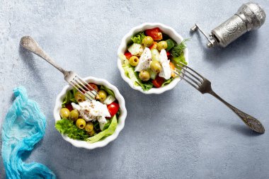 Beyaz kaselerde Yunan salatası, taze salata.