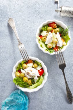 Beyaz kaselerde Yunan salatası, taze salata.