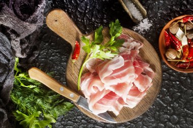 Tahtada çiğ domuz pastırması, tuzlu domuz pastırması ve baharat.