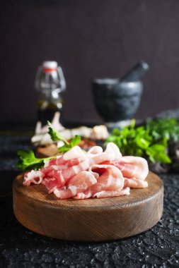 Tahtada çiğ domuz pastırması, tuzlu domuz pastırması ve baharat.