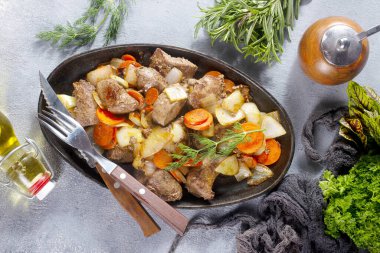 Patatesli kızarmış ciğer ve metal tabakta sebze.