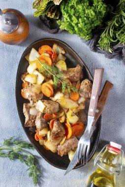 Patatesli kızarmış ciğer ve metal tabakta sebze.