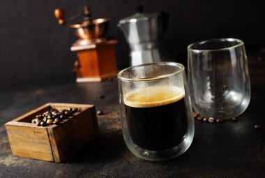 Masanın üzerinde cam bir kuo ile kahve içiyorum.