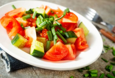 Domatesli taze salata ve tabakta salatalık.