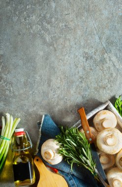 Çiğ mantarlar taze otlar ve gri masada baharat.