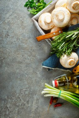 Çiğ mantarlar taze otlar ve gri masada baharat.