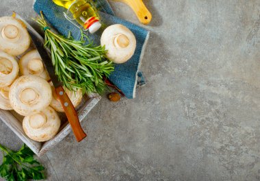 Çiğ mantarlar taze otlar ve gri masada baharat.