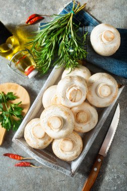 Çiğ mantarlar taze otlar ve gri masada baharat.